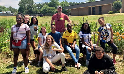 Irmo Middle School students pose in front of their schoolyard habitat
